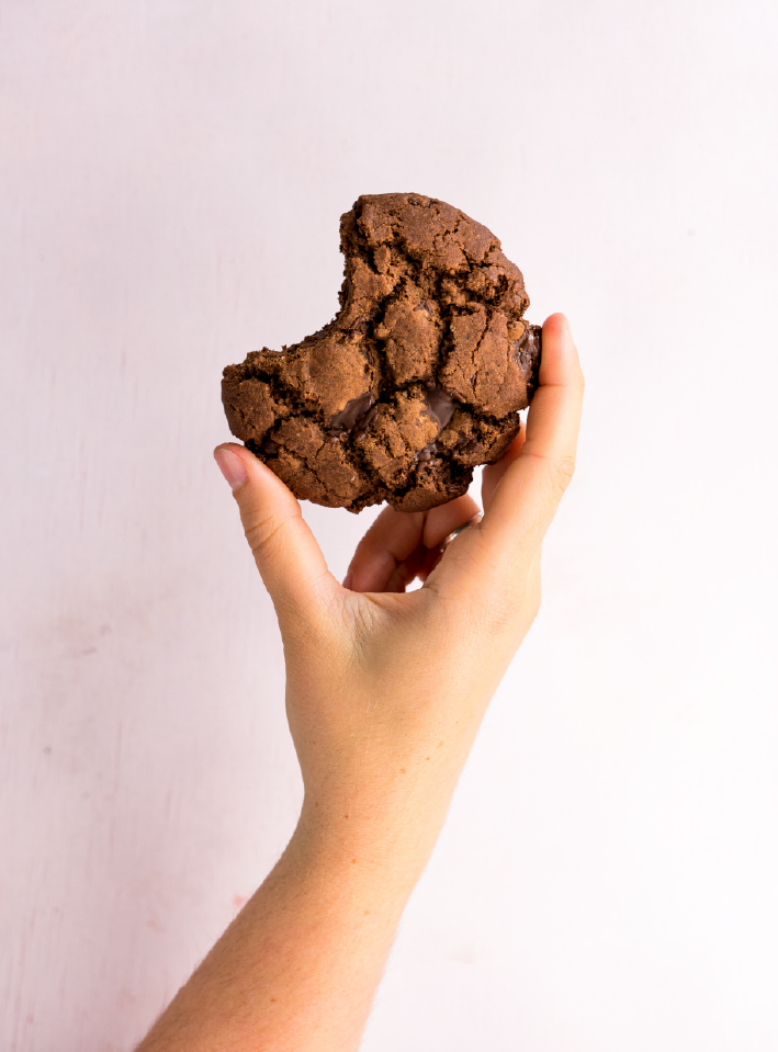 Hand håller brownie-cookie